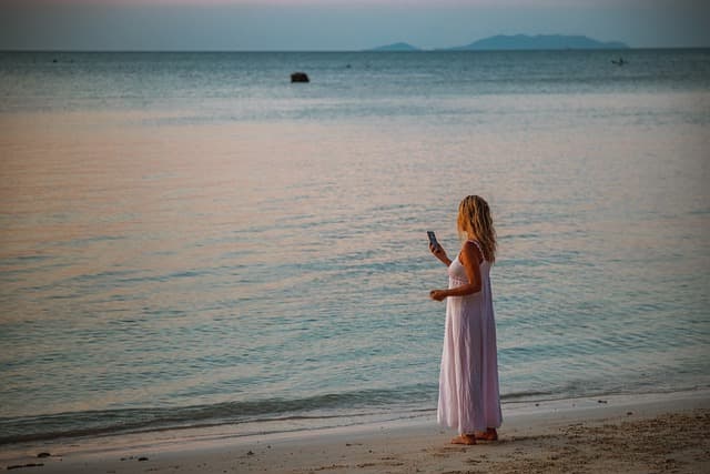 wait for a call, taking photos, woman, blond, beach, water, sunset, photography, camera, smartphone, photo, mobile, female, people, to travel, person, phone, lifestyle, picture, nature, wait, reception, cell phone reception